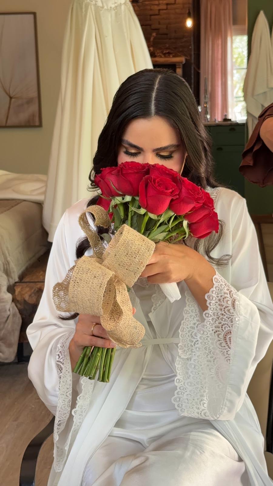 Noiva com um buquê de rosas vermelhas durante os preparativos